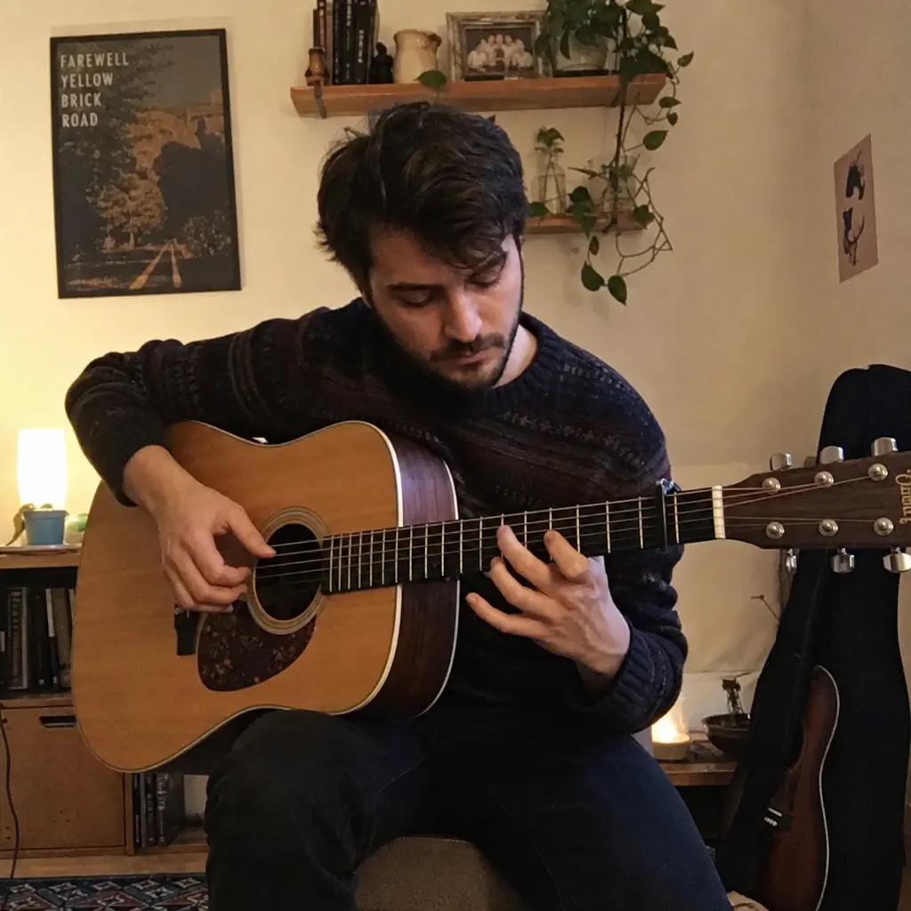 Guitarist fingerpicking an acoustic guitar in a home music room